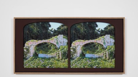 Duplicate photographs are positioned side by side within arched frames. The photograph depicts a dilapidated stone archway overrun by greenery.