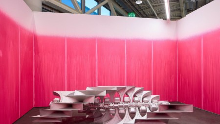 A metalic sculpture surrounded by pink walls.