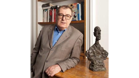 Daniel Lelong poses next to a sculpture by Alberto Giacometti.