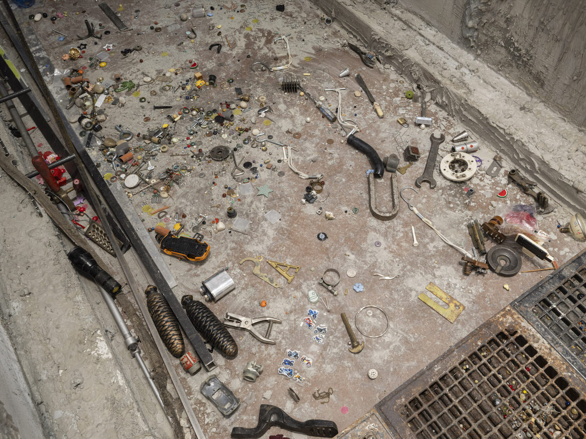 An array of tools on a dirty floor.