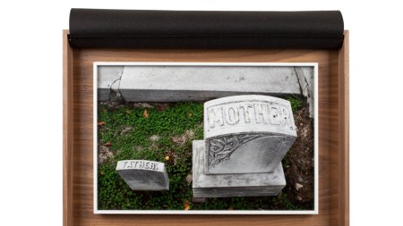 Picture of two graves. A large one says mother and small one says father.