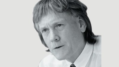 Black-and-white portrait of a middle-aged white man with long hair