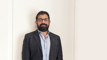 A portrait of a Brown man with a suit jacjet.