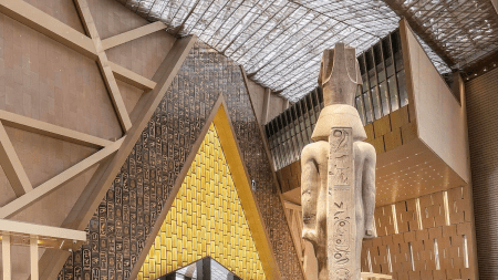 A large atrium dominated by a tall Egyptian statue and a triangular entryway.