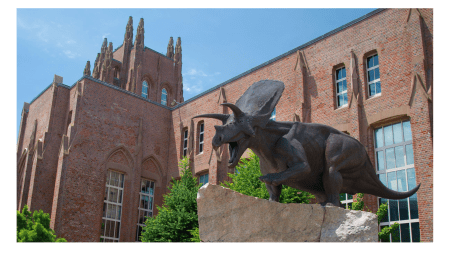 An old building with spires and a dinosaur.